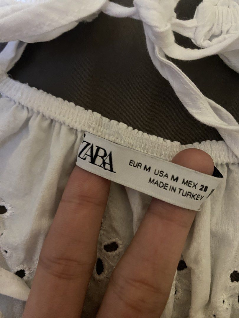 Zara White Eyelet Halter Top Size M (Category: Sleeveless) located in Abucay. Submitted by mawimawmaw (Listing ID 1466432002, Image 2). Description: - Brand: Zara - Size: M (Made in Turkey) - Material: Lightweight cotton - Design: All-over eyelet embroidery with a scalloped hem - Details: Adjustable criss-cross back straps and front tie closure - Style: Perfect for warm weather, beach trips, and pairing with shorts or skirts.