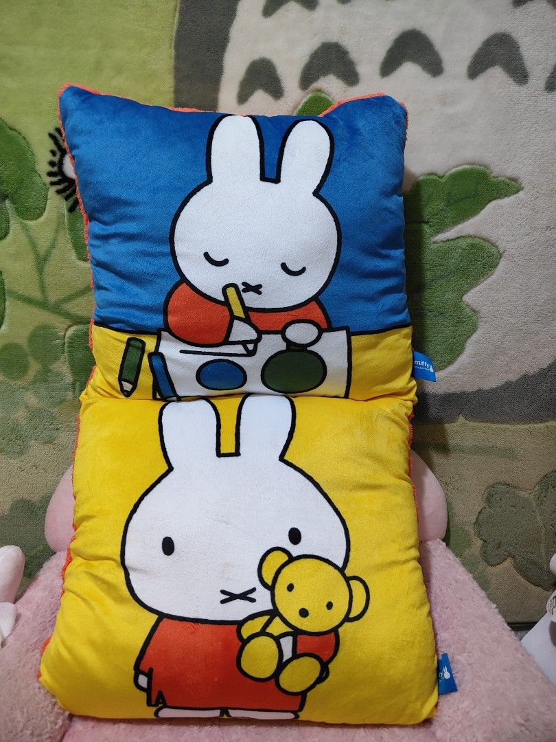 2 pcs Miffy pillow (Category: Bedding & Towels) located in Naic. Submitted by rmcollectibles (Listing ID 1466687558, Image 1). Description: - Official Miffy Amusement plush cushion - Double-sided design: Blue side features Miffy painting, yellow side features Miffy holding a teddy bear - Back side is made of solid orange plush material - Soft and huggable fabric construction - Complete with blue official tags attached - Perfect cute decor piece f