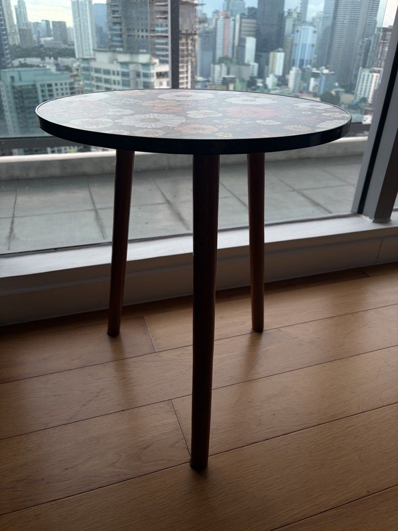 Accent Side Table with Wooden Legs (Category: Tables & Sets) located in Mandaluyong City. Submitted by vickydeclutter (Listing ID 1466640180, Image 3). Description: I was using it for my portrait display and some candles. This is decorative table only Price negotiable - Type: Round side table - Design: Dark floral print with vibrant white, yellow, and red flowers - Build: Sturdy tabletop with smooth edges and three screw-in wooden legs with secur