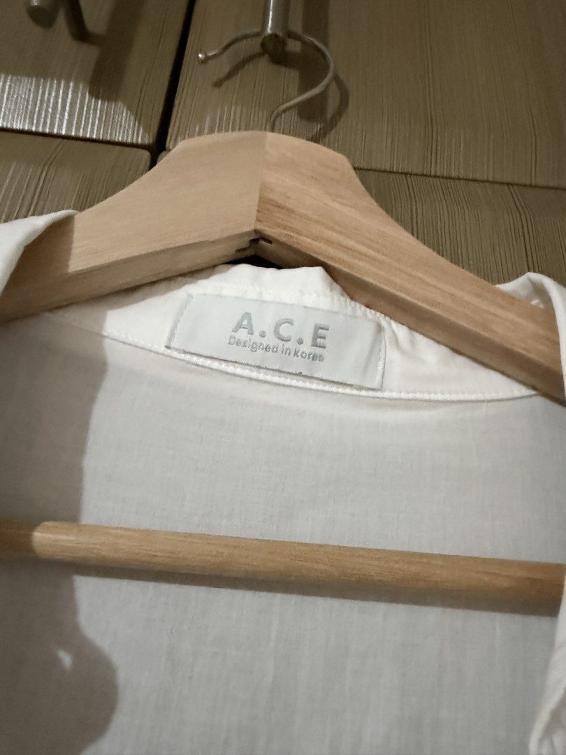 A.C.E. Designed in Korea White Button-Up Shirt (Category: Shirts) located in Taguig. Submitted by mengxir20193848 (Listing ID 1466673040, Image 3). Description: - Brand: A.C.E. (Designed in Korea) - Color: Classic White - Style: Korean streetwear, versatile neutral staple - Fit/Material: Lightweight, slightly sheer, long sleeves with classic collar and front button closure - Versatility: Easy to wear solo or layer over a tank top.
