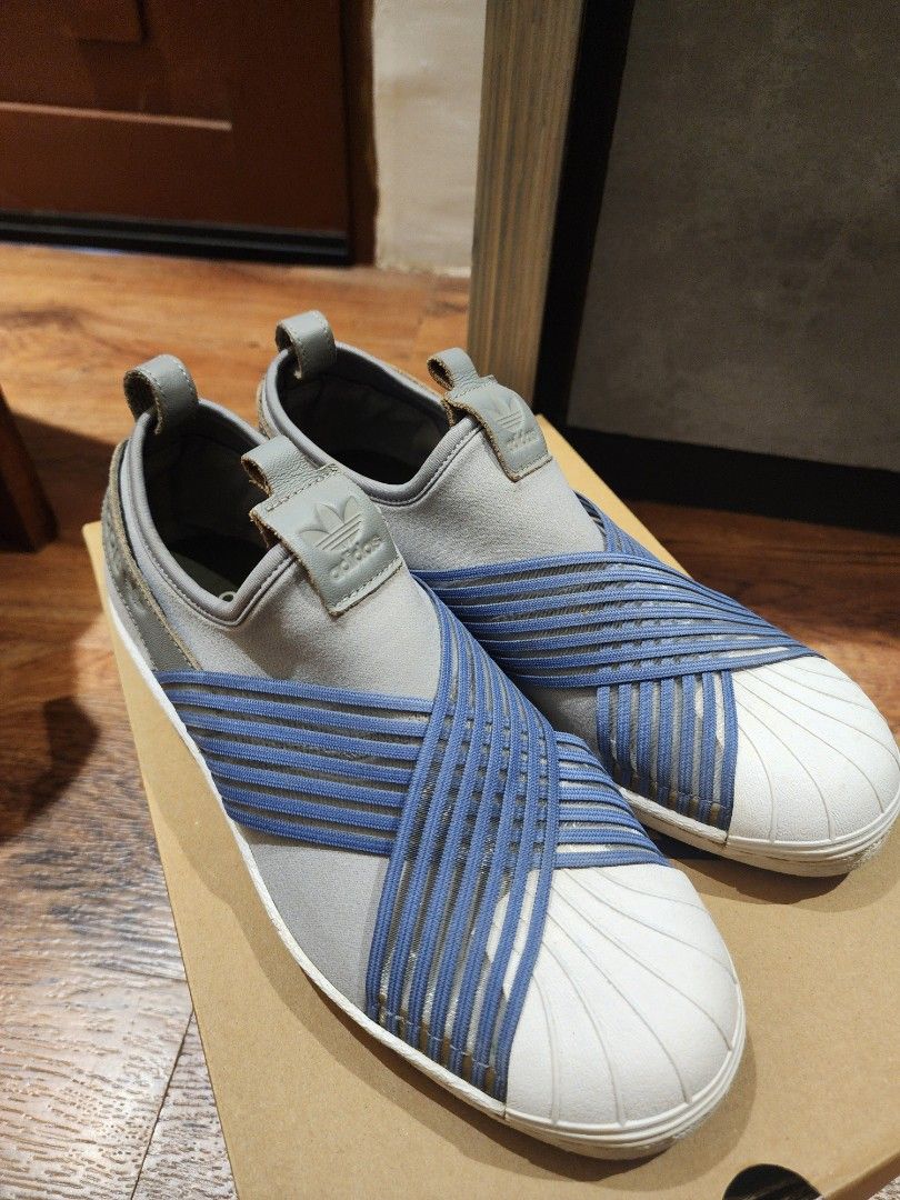Adidas Superstar Slip-On Grey Blue (Category: Sneakers) located in Manila. Submitted by kg613 (Listing ID 1466773503, Image 3). Description: - Brand: Adidas - Style: Slip-on sneakers in grey with blue elastic criss-cross straps - Design: Iconic white rubber shell toe and clean white midsoles - Details: Leather pull tabs at heel and tongue with embossed Adidas trefoil logo - Convenience: Quick and easy to slip on - Condition/Usage: Great everyday 