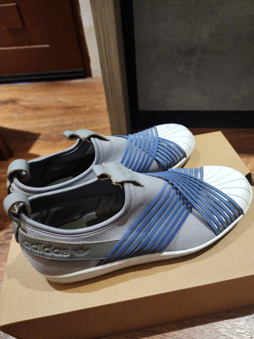 Adidas Superstar Slip-On Grey Blue (Category: Sneakers) located in Manila. Submitted by kg613 (Listing ID 1466773503, Image 2). Description: - Brand: Adidas - Style: Slip-on sneakers in grey with blue elastic criss-cross straps - Design: Iconic white rubber shell toe and clean white midsoles - Details: Leather pull tabs at heel and tongue with embossed Adidas trefoil logo - Convenience: Quick and easy to slip on - Condition/Usage: Great everyday 
