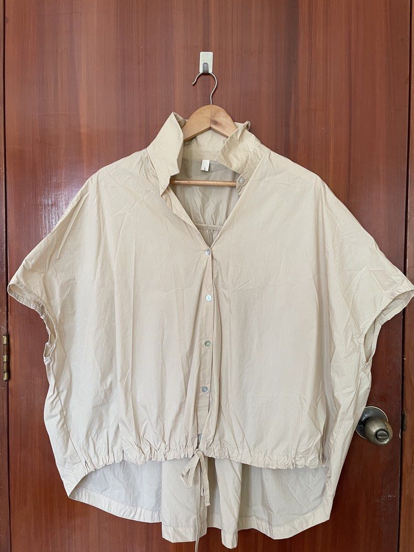 Africa Beige Oversized Button-Up Short Sleeve Blouse (Category: Blouses) located in Cebu City. Submitted by annyeongthriftcebu (Listing ID 1466632871, Image 1). Description: - Style: Oversized button-up blouse with short sleeves - Color: Versatile neutral beige (goes with everything!) - Origin: From Africa - Details: High collar, front button closure, and adjustable hem tie - Fit & Comfort: Crisp cotton-blend fabric with gathers across the back y