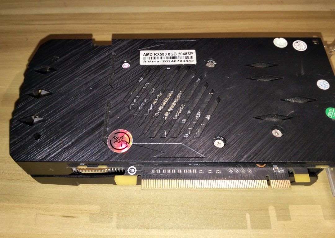 Aisurix AMD RX 580 8GB 2048SP GPU (Category: Computer Parts) located in Marikina City. Submitted by rareocean_9df934 (Listing ID 1466769411, Image 2). Description: - Brand/Model: Aisurix AMD RX 580 - Memory: 8GB VRAM with 2048 stream processors - Cooling: Dual fan setup with copper heat pipes - Design: Sleek black shroud with red accents and backplate with cooling slots - Condition: Clean unit, manufacturer stickers intact, standard PCIe interfac