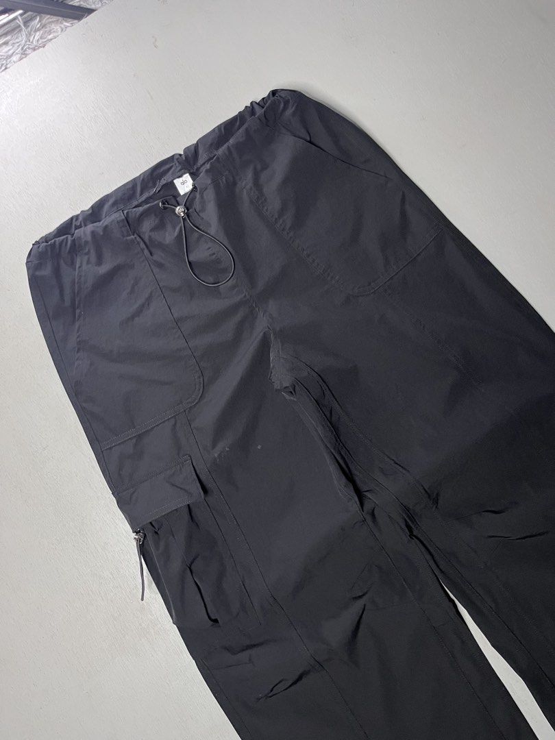Alo Yoga Black Cargo Pants (Category: Jeans) located in Catbalogan. Submitted by yellfindss (Listing ID 1466751787, Image 2). Description: - Brand: Alo Yoga -28-34 adjustable waist / 38 lo 9 - Item: Utility Cargo Pants - Color: Black - Material: Lightweight nylon - Fit: Relaxed wide-leg - Waistband: Drawstring with toggle hardware - Pockets: Multiple, including side cargo compartments - Cuffs: Adjustable drawstrings with metal stoppers - Branding