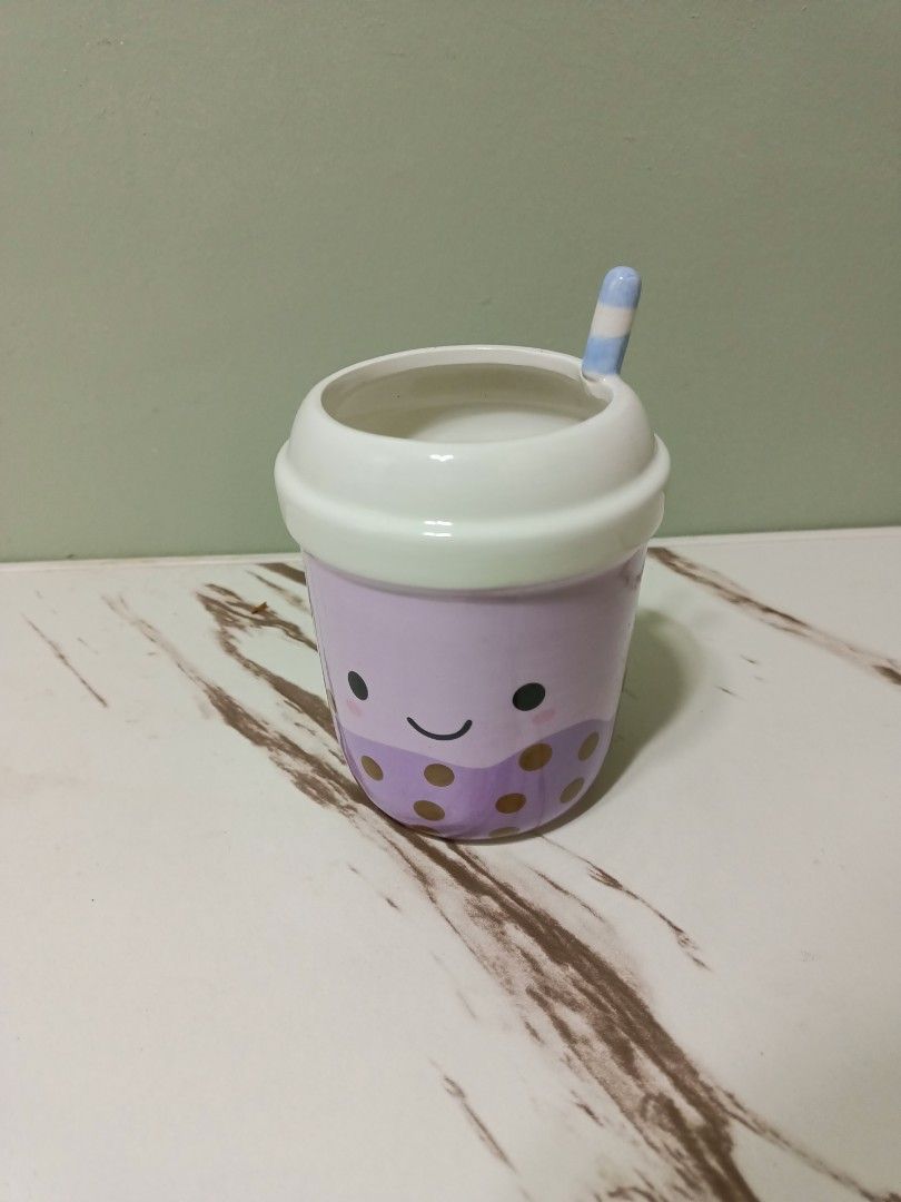 Anko Boba Tea Pen Cup (Category: Water Bottles & Tumblers) located in Antipolo. Submitted by cathrift_ (Listing ID 1466724331, Image 2). Description: - Brand: Anko - Design: Cute purple boba tea with a face, tapioca pearls, white lid, and blue striped straw - Multipurpose: Great for holding pens, pencils, or makeup brushes - Condition: Clean, unused, and original sticker still attached on the bottom - Perfect aesthetic desk accessory.