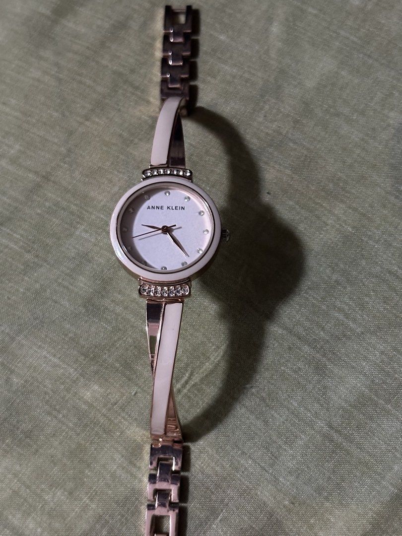 Anne Klein Rose Gold and White Bangle Watch (Category: Women's Watches) located in Manila. Submitted by preloved_by_ea (Listing ID 1466583140, Image 3). Description: - unit only Brand: Anne Klein - Color: Elegant rose gold tone with white enamel inlay - Dial: Sparkling crystal hour markers - Accents: Sparkling stones set above and below the round case - Closure: Adjustable link clasp on the back - Condition: Minimal wear overall, well-maintained 