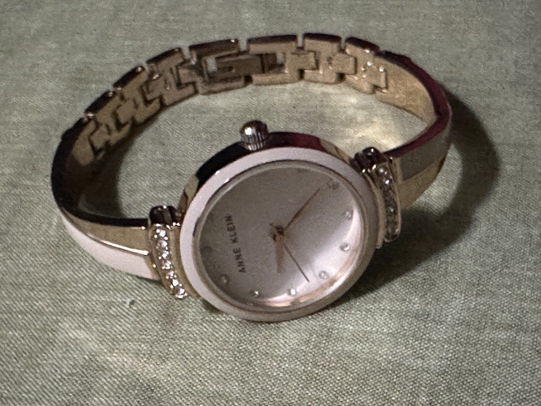 Anne Klein Rose Gold and White Bangle Watch (Category: Women's Watches) located in Manila. Submitted by preloved_by_ea (Listing ID 1466583140, Image 1). Description: - unit only Brand: Anne Klein - Color: Elegant rose gold tone with white enamel inlay - Dial: Sparkling crystal hour markers - Accents: Sparkling stones set above and below the round case - Closure: Adjustable link clasp on the back - Condition: Minimal wear overall, well-maintained 