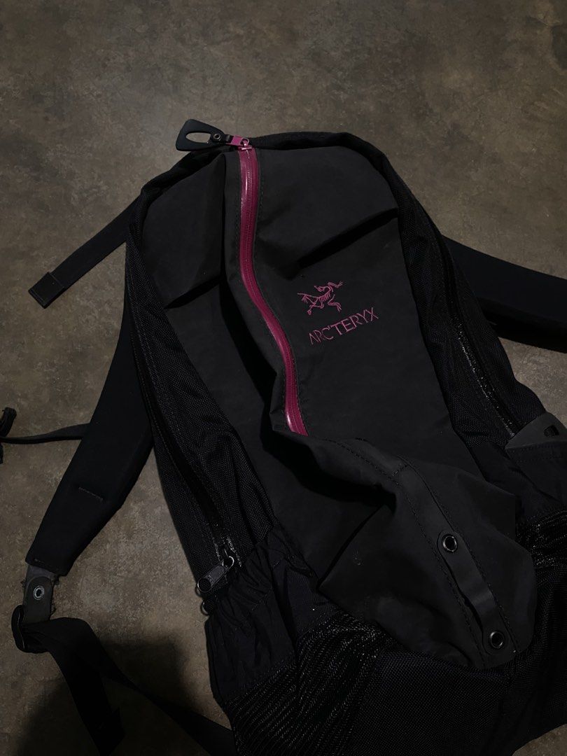 Arc'teryx Black and Magenta Backpack (Category: Backpacks) located in Manila. Submitted by zayneeee. (Listing ID 1466706727, Image 2). Description: Black Arc'teryx backpack with vibrant magenta branding and matching water-resistant main zipper. Breathable mesh side pockets for water bottles or quick-access gear. Molded back panel with embossed fossil logo for carrying comfort. Adjustable shoulder straps with strap management keepers and utility l