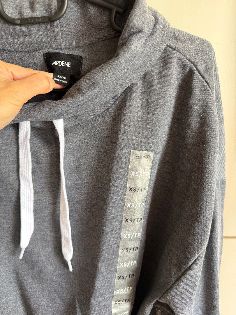 Ardene Gray Cropped Hoodie with Drawstrings Size XS (Category: Coats, Jackets and Outerwear) located in Quezon City. Submitted by bubspreloved (Listing ID 1466701271, Image 2). Description: - Brand: Ardene - Size: XS - Color: Heather Gray - Style: Cropped hoodie with high cowl neck - Details: White adjustable drawstrings on collar and hem for a cinched look - Cuffs: Long sleeves with ribbed cuffs - Fabric: Soft and comfortable - Condition: Great 