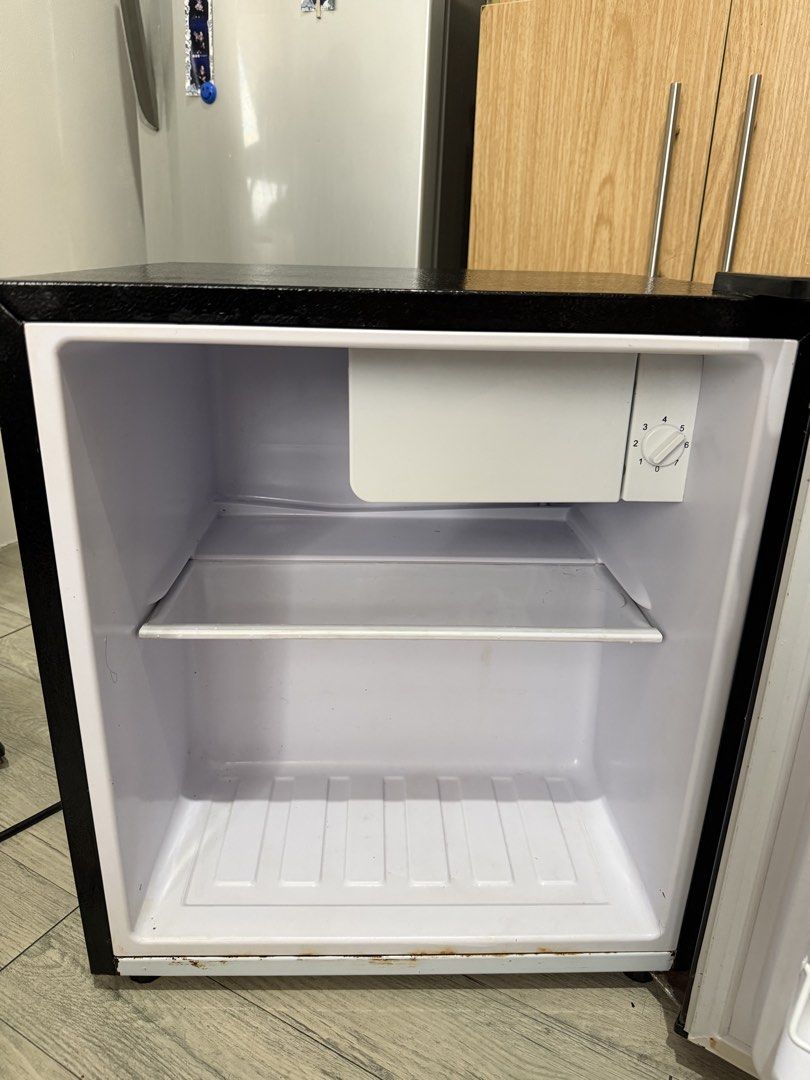 Astron RF1-17 1.7 Cu. Ft. Mini Refrigerator Black (Category: Refrigerators and Freezers) located in Manila. Submitted by vallen03 (Listing ID 1466577287, Image 2). Description: - Brand: Astron - Capacity: 1.7 cubic feet - Color: Black - Features: Removable wire shelf, small freezer compartment with temperature dial, and door storage racks - Condition: Clean interior, with some exterior scuffs and minor rust spotting near the bottom door frame - I