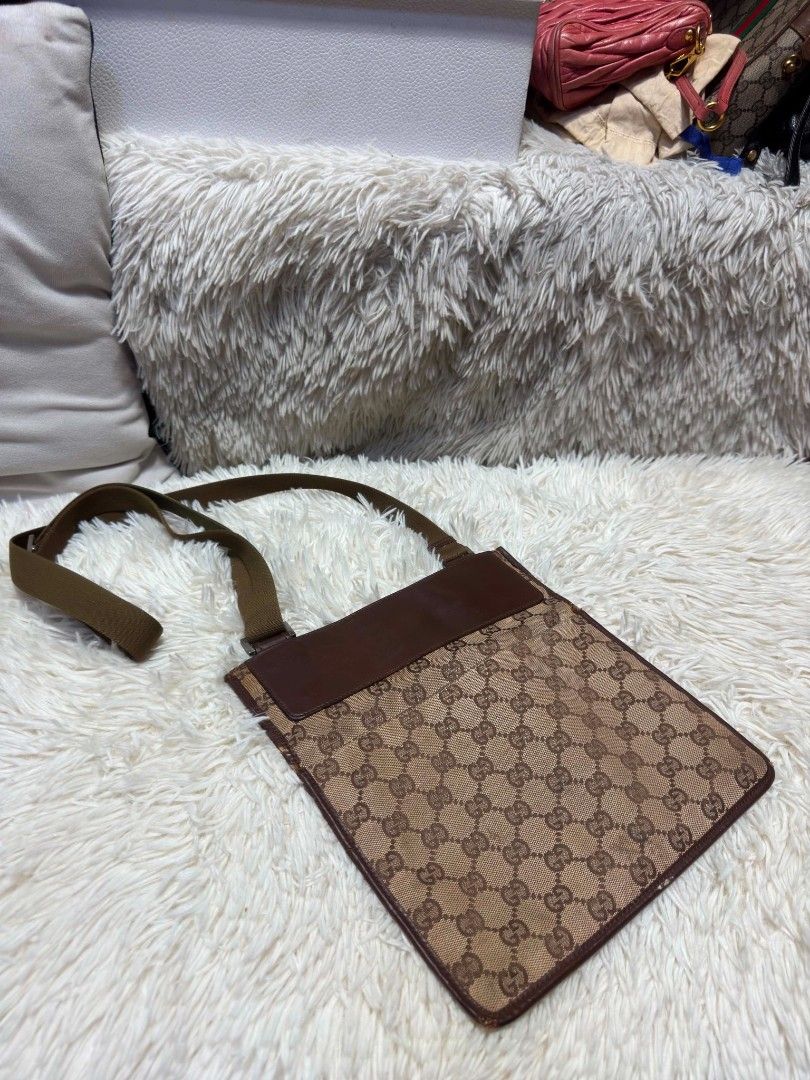Authentic Gucci GG Monogram Canvas Crossbody Bag Brown (Category: Luxury Bags & Wallets) located in Marikina City. Submitted by aussiemaan (Listing ID 1466629138, Image 2). Description: - Authentic Gucci crossbody bag in classic brown monogram canvas - Features dark brown leather trim, silver-tone hardware plaque, and flat messenger style - Long adjustable web strap for comfortable wear - Condition: Shows noticeable scuffing and wear on the botto