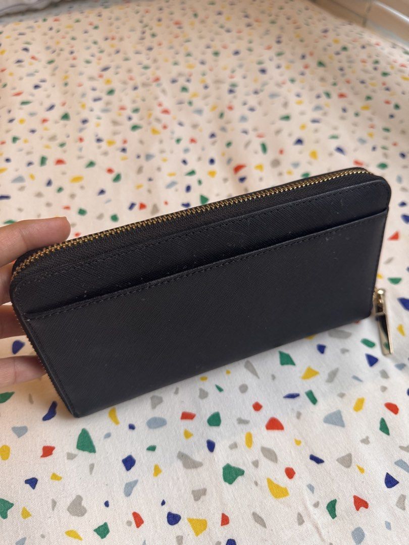 Authentic Kate Spade New York black zip-around wallet (Category: Wallets & Card holders) located in Makati City. Submitted by lpcalundan (Listing ID 1466566466, Image 3). Description: - Brand: Kate Spade New York - Material: Black textured leather with gold-tone hardware and front logo - Closure: Zip-around with pull tab - Exterior: Convenient back slip pocket - Interior: Chic black-and-white striped lining, multiple card slots, bill compartments