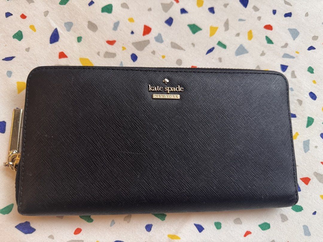 Authentic Kate Spade New York black zip-around wallet (Category: Wallets & Card holders) located in Makati City. Submitted by lpcalundan (Listing ID 1466566466, Image 1). Description: - Brand: Kate Spade New York - Material: Black textured leather with gold-tone hardware and front logo - Closure: Zip-around with pull tab - Exterior: Convenient back slip pocket - Interior: Chic black-and-white striped lining, multiple card slots, bill compartments