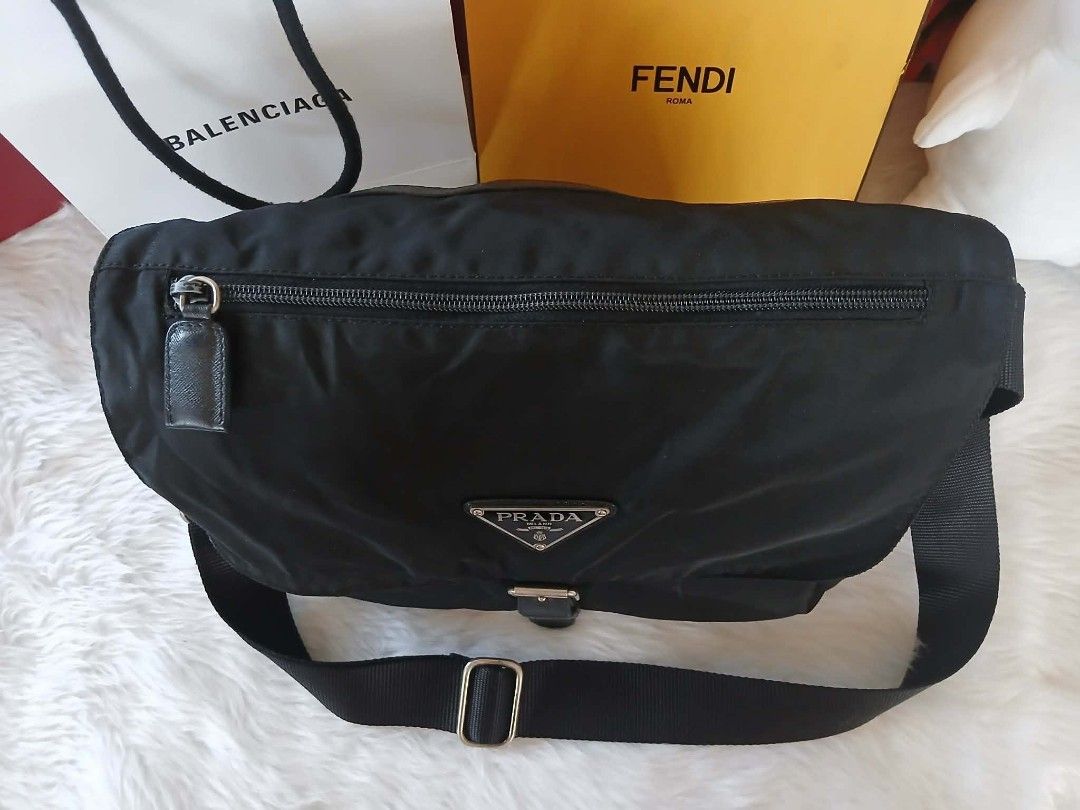 Authentic Prada Black Nylon Messenger Bag (Category: Luxury Bags & Wallets) located in Marikina City. Submitted by aussiemaan (Listing ID 1466631113, Image 2). Description: Black nylon messenger bag from Prada. Classic triangle logo plaque on the front flap. Adjustable black web strap with metal hardware. Buckle closure securing the front flap. Zipper pocket on the top flap. Clean stitching and structured shape. Great daily carryall for work or t