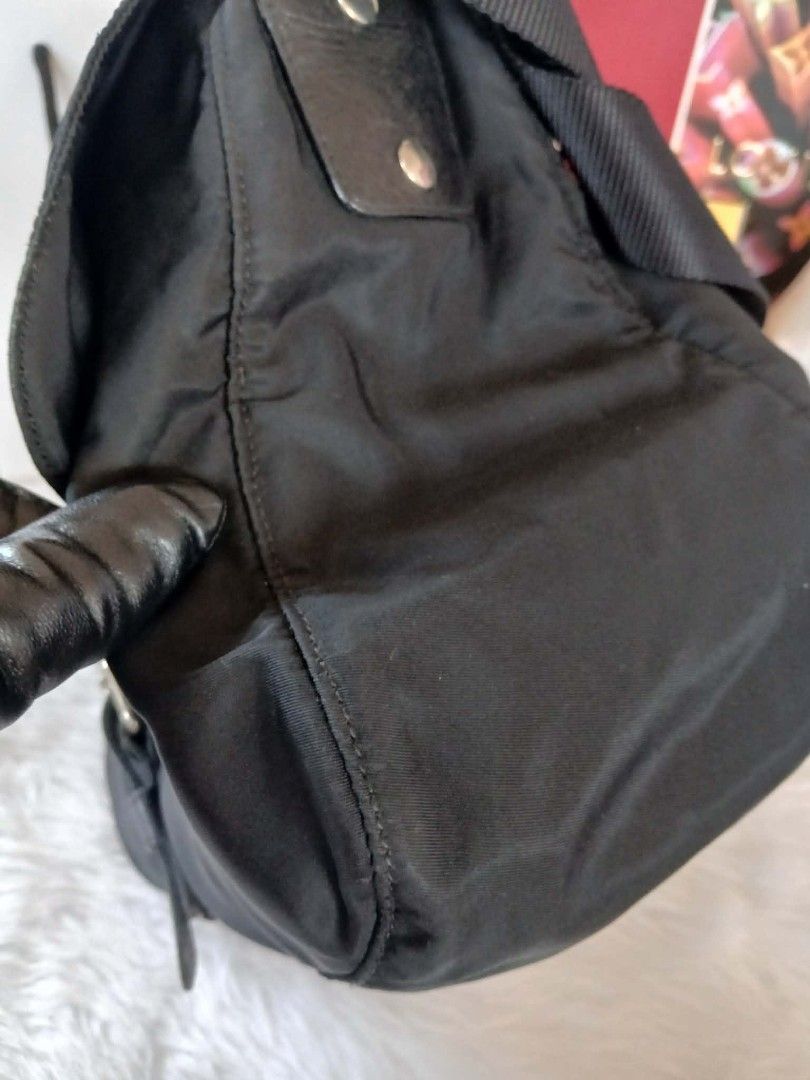 Authentic Prada Black Nylon Messenger Bag (Category: Luxury Bags & Wallets) located in Marikina City. Submitted by aussiemaan (Listing ID 1466631113, Image 3). Description: Black nylon messenger bag from Prada. Classic triangle logo plaque on the front flap. Adjustable black web strap with metal hardware. Buckle closure securing the front flap. Zipper pocket on the top flap. Clean stitching and structured shape. Great daily carryall for work or t