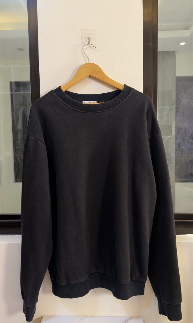 Balenciaga Back Patch Logo Sweatshirt Black Size L (Category: Luxury Apparel) located in Paranaque City. Submitted by mykapoynton (Listing ID 1466769548, Image 2). Description: Balenciaga Back Patch Logo Sweatshirt Black Size L - Color: Washed black - Size: L (Tag and care label attached) - Unique distressed denim patch across upper back with blue embroidered branding - Ribbed crewneck, cuffs, and hem - Relaxed, straight-on-body fit - Made in Por