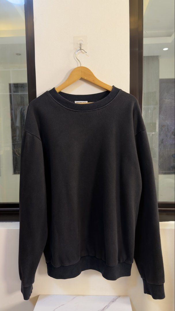 Balenciaga Back Patch Logo Sweatshirt Black Size L (Category: Coats, Jackets and Outerwear) located in Paranaque City. Submitted by preluxeshop_ph (Listing ID 1466769592, Image 2). Description: Balenciaga Back Patch Logo Sweatshirt Black Size L - Color: Washed black - Size: L (Tag and care label attached) - Unique distressed denim patch across upper back with blue embroidered branding - Ribbed crewneck, cuffs, and hem - Relaxed, straight-on-body 