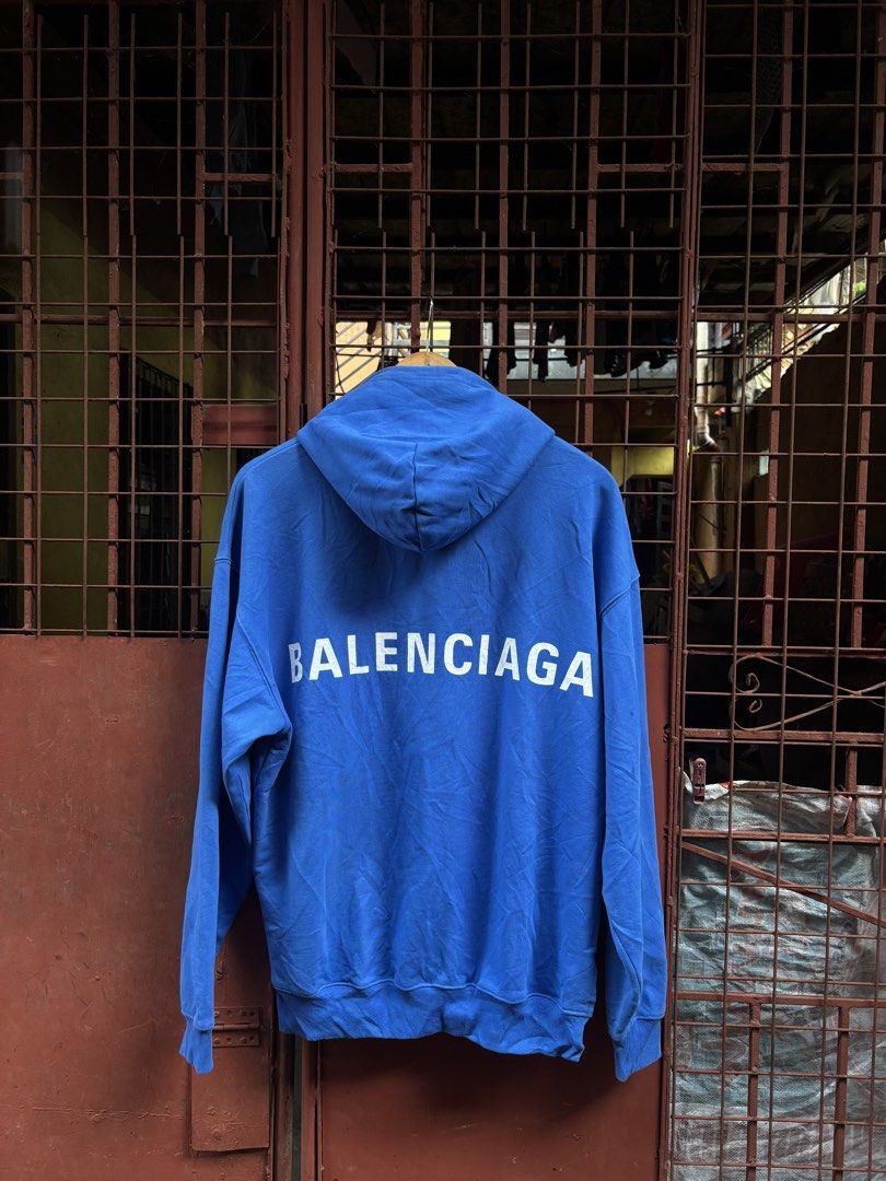 Balenciaga Blue Hooded Sweatshirt (Category: Hoodies) located in Manila. Submitted by thriftkibs (Listing ID 1466716199, Image 1). Description: - Authentic Balenciaga hoodie in vibrant blue - Size S with clear tag details and product codes - Bold white logo printed on the back - Classic pullover with drawstring hood and kangaroo pocket - Crafted in Portugal from premium cotton French terry - Clean and ready to wear condition.