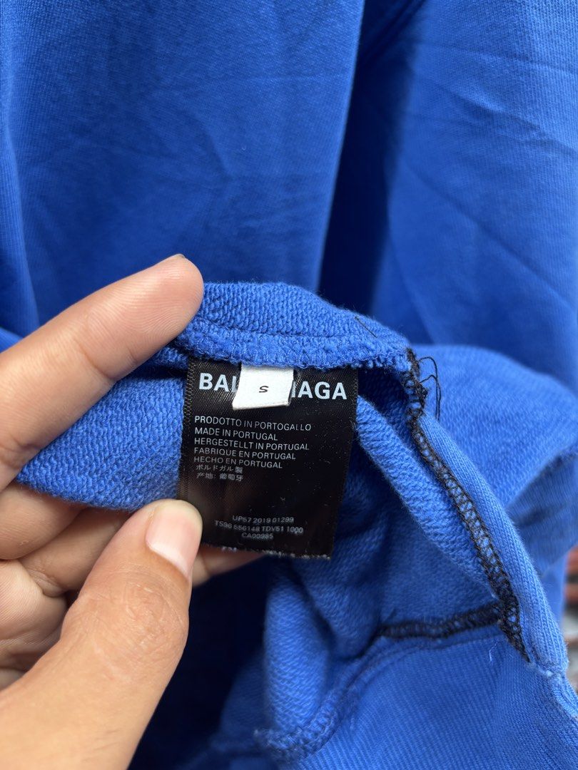 Balenciaga Blue Hooded Sweatshirt (Category: Hoodies) located in Manila. Submitted by thriftkibs (Listing ID 1466716199, Image 3). Description: - Authentic Balenciaga hoodie in vibrant blue - Size S with clear tag details and product codes - Bold white logo printed on the back - Classic pullover with drawstring hood and kangaroo pocket - Crafted in Portugal from premium cotton French terry - Clean and ready to wear condition.