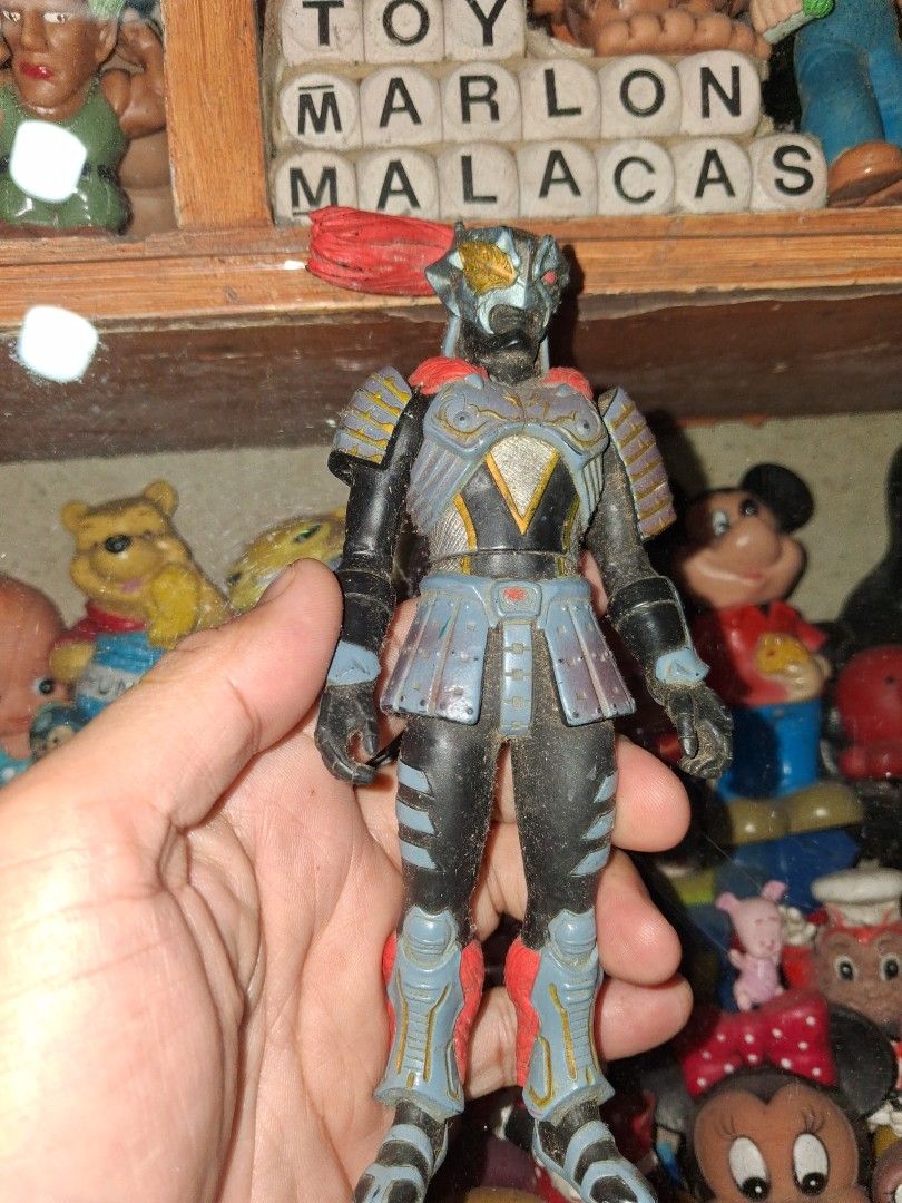 Bandai 2006 Samurai Action Figure (Category: Figurines & Statues) located in Manila. Submitted by marcas022798212 (Listing ID 1466698434, Image 1). Description: Bandai action figure from 2006. Detailed samurai armor design with black, grey, and red elements. Stands about tall. Stamped on the bottom of the foot with Bandai 2006 and China 41712. Dusty from storage, needs cleaning. Good piece for collectors..