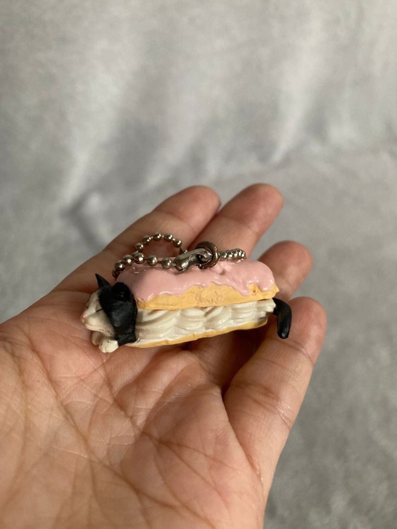 Bandai Neko Cafe 6 Cat Eclair Pastry Keychain (Category: Character Goods) located in Rizal. Submitted by sheeraay (Listing ID 1466650268, Image 1). Description: - 100% Authentic Official Bandai Gachapon - Adorable tuxedo cat hiding inside a pink-glazed eclair with cream filling - Comes with a sturdy metal ball chain for easy attachment - Authenticated with official Bandai copyright and China production stamps on the bottom - Compact and lightweig