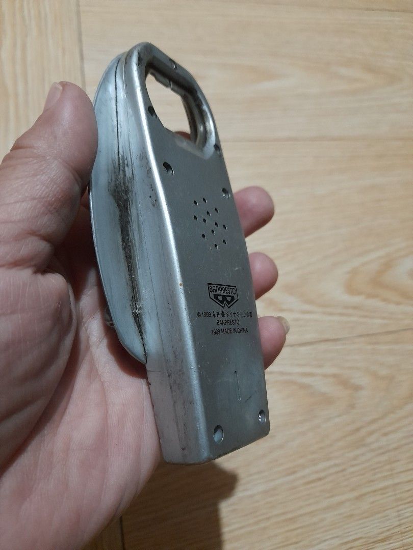 Banpresto Vintage Bottle Opener (Category: Vintage Collectibles) located in Bocaue. Submitted by marajapansurplus (Listing ID 1466710336, Image 3). Description: - Authentic 1999 Banpresto novelty bottle opener - Features a silver plastic body with a detailed metallic figure relief on the front - Designed with a built-in speaker grille on the back and official copyright stamp near the bottom - Rare vintage collectible piece still retains its origi