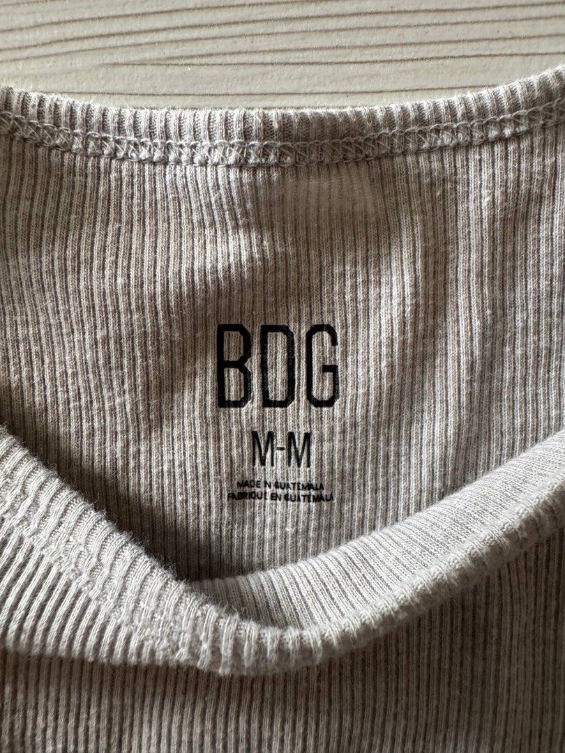BDG Ribbed Crop Top Grey Size M (Category: Shirts) located in Taguig. Submitted by anxmz (Listing ID 1466674664, Image 2). Description: - Used once - Brand: BDG - Color: Grey - Size: Medium (true to size) - Material: Super soft stretch fabric - Details: Ribbed texture, short sleeves, round neckline - Origin: Made in Guatemala - Style: Casual everyday basic, perfect with jeans or high-waisted shorts.