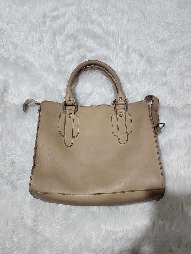 Beige handbag with double top handles (Category: Shoulder Bags) located in Manila. Submitted by rionbenedicto (Listing ID 1466586804, Image 2). Description: - Color: Neutral beige that matches any outfit - Hardware: Sleek silver hardware with a secure zipper top closure - Design: Structured top handles and side rings for an optional strap - Capacity: Everyday size with enough space for your daily essentials - Condition: Preloved, good overall..