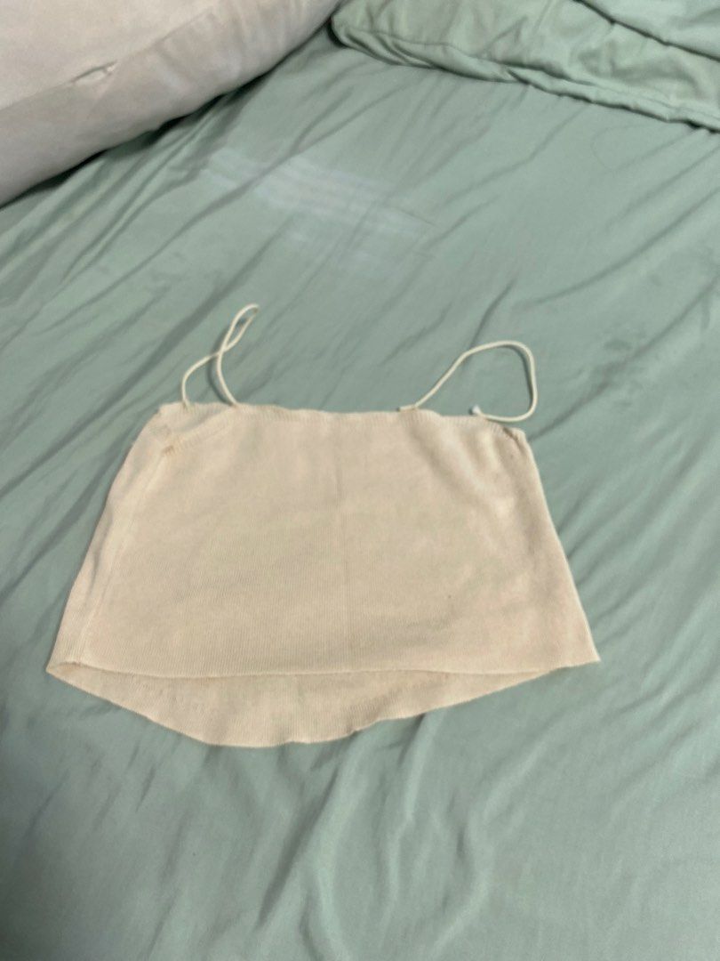 Beige Knit Camisole with White Bows (Category: Sleeveless) located in Las Pinas. Submitted by andwe_yaa (Listing ID 1466612189, Image 2). Description: - Color: Beige - Material: Soft ribbed knit - Design: Thin spaghetti straps and a flattering curved hem - Detail: Five charming white satin bows scattered on the front - Style: Dainty, cute, and casual - Pairing: Perfect to match with high-waisted jeans or skirts -May need extra stitching of Straps
