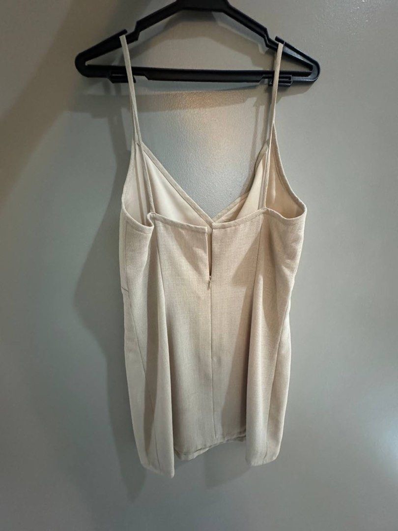 Beige wrap front spaghetti strap mini dress (Category: Dresses) located in Taguig. Submitted by anxmz (Listing ID 1466605623, Image 2). Description: - Color: Classic beige - Design: Spaghetti straps with crossover V-neck front - Fabric: Textured linen-look with subtle vertical weave, fully lined - Closure: Convenient back zipper - Fit: Fits roughly around a Medium (size tag print has faded) - Style: Simple and versatile for warm days or casual ni