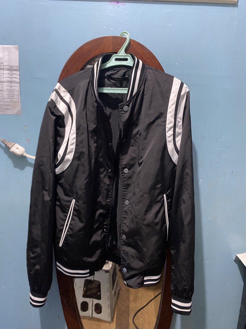 Black and White Bomber Jacket (Category: Coats, Jackets and Outerwear) located in Manila. Submitted by mimi_goods.ph (Listing ID 1466598775, Image 1). Description: - Color: Black and white - Style: Classic varsity bomber jacket - Closure: Snap-button front - Details: Striped ribbed collar, cuffs, and hem with contrast white sleeve stripes - Pockets: Two front welt pockets - Material: Lightweight, ideal for layering over a t-shirt.