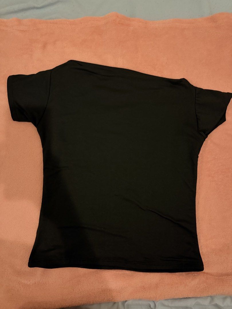 Black Asymmetric Off-Shoulder Short Sleeve Top (Category: Blouses) located in Pasig City. Submitted by shop.gelss (Listing ID 1466769842, Image 2). Description: - Color: Classic Black - Style: Asymmetric neckline with a trendy one-shoulder cut - Fit: Slim, body-hugging silhouette - Fabric: Smooth, high-stretch material for all-day comfort - Versatility: Essential basic piece, perfect for pairing with denim, skirts, or tailored trousers - Conditio