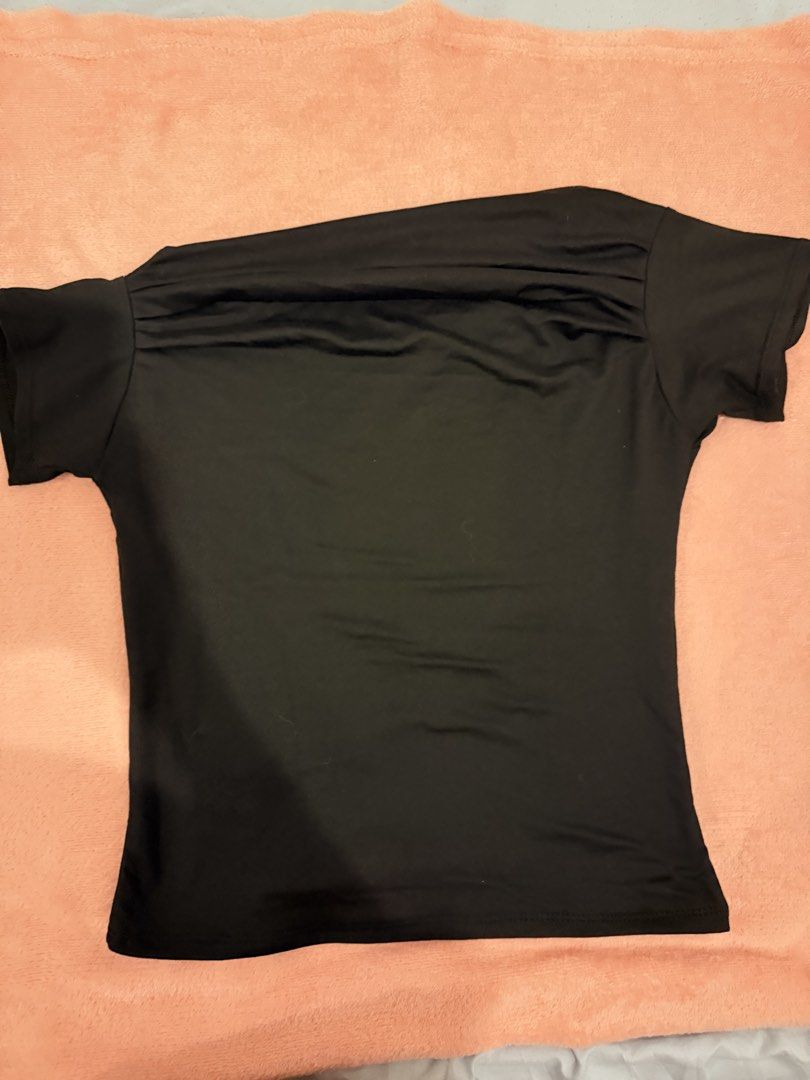 Black Asymmetric Off-Shoulder Short Sleeve Top (Category: Blouses) located in Pasig City. Submitted by shop.gelss (Listing ID 1466769842, Image 1). Description: - Color: Classic Black - Style: Asymmetric neckline with a trendy one-shoulder cut - Fit: Slim, body-hugging silhouette - Fabric: Smooth, high-stretch material for all-day comfort - Versatility: Essential basic piece, perfect for pairing with denim, skirts, or tailored trousers - Conditio