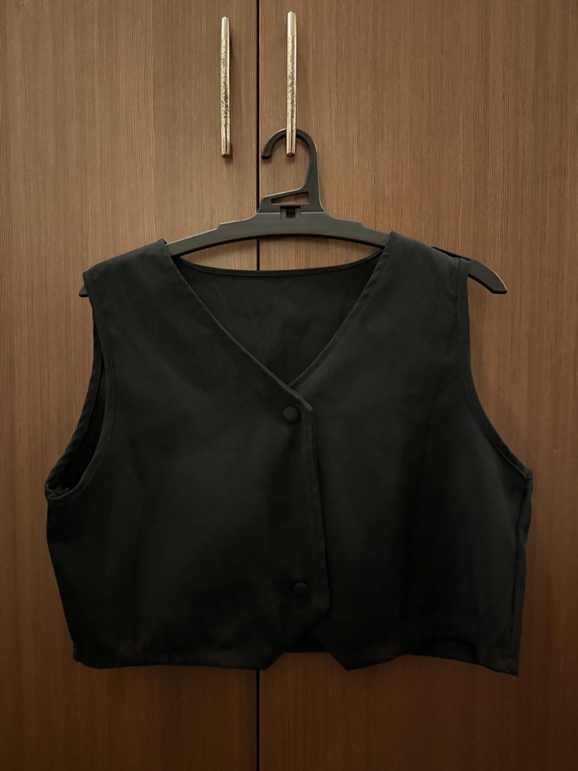 Black Cropped Vest with Buttons (Category: Sleeveless) located in Pasig City. Submitted by shop.gelss (Listing ID 1466769899, Image 2). Description: - Color: Black - Style: Sleeveless cropped vest with V-neck and pointed hem - Closure: Two front buttons - Material: Lightweight fabric - Fit: Great with high-waisted pants or skirts - Condition: Clean, minimal wear.