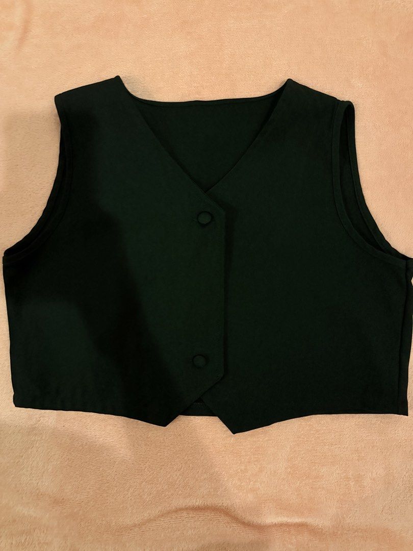 Black Cropped Vest with Buttons (Category: Sleeveless) located in Pasig City. Submitted by shop.gelss (Listing ID 1466769899, Image 1). Description: - Color: Black - Style: Sleeveless cropped vest with V-neck and pointed hem - Closure: Two front buttons - Material: Lightweight fabric - Fit: Great with high-waisted pants or skirts - Condition: Clean, minimal wear.