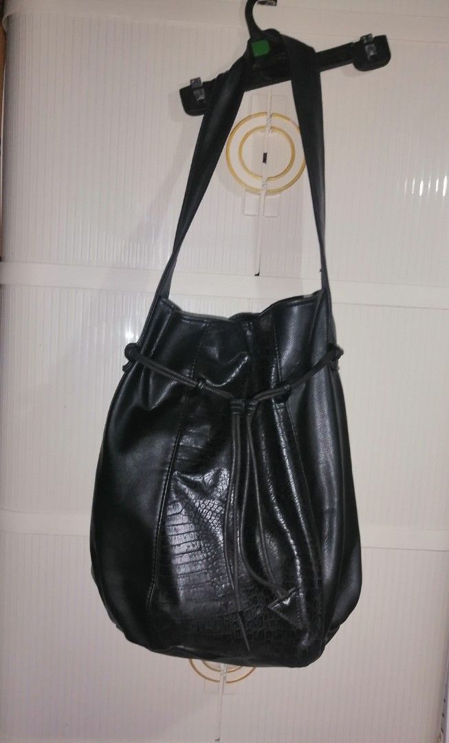 Black Faux Leather Shoulder Bag with Textured Panel (Category: Shoulder Bags) located in Quezon City. Submitted by rolenalma (Listing ID 1466582822, Image 3). Description: - Material: Smooth black faux leather with a textured animal print center panel - Design: Slouchy shape with a front drawstring detail and hanging tabs - Straps: Single wide strap for comfortable shoulder or arm carry - Interior: Spacious main compartment with a clean black lin
