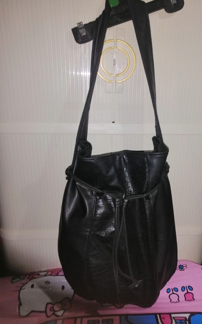 Black Faux Leather Shoulder Bag with Textured Panel (Category: Shoulder Bags) located in Quezon City. Submitted by rolenalma (Listing ID 1466582822, Image 2). Description: - Material: Smooth black faux leather with a textured animal print center panel - Design: Slouchy shape with a front drawstring detail and hanging tabs - Straps: Single wide strap for comfortable shoulder or arm carry - Interior: Spacious main compartment with a clean black lin