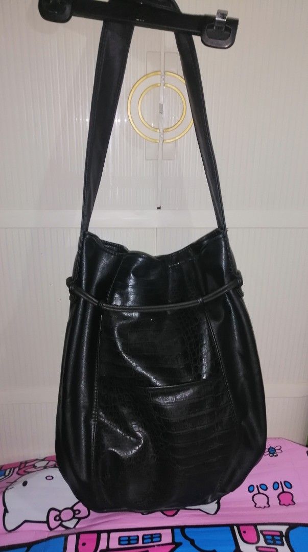 Black Faux Leather Shoulder Bag with Textured Panel (Category: Shoulder Bags) located in Quezon City. Submitted by rolenalma (Listing ID 1466582822, Image 1). Description: - Material: Smooth black faux leather with a textured animal print center panel - Design: Slouchy shape with a front drawstring detail and hanging tabs - Straps: Single wide strap for comfortable shoulder or arm carry - Interior: Spacious main compartment with a clean black lin