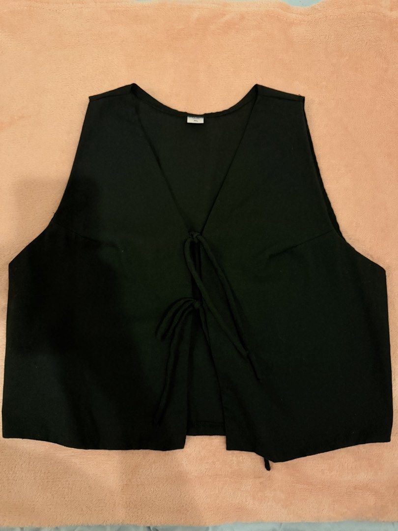 Black Front Tie Crop Vest Top Size XL (Category: Sleeveless) located in Pasig City. Submitted by shop.gelss (Listing ID 1466770295, Image 1). Description: - Color: Black - Size: XL - Style: Sleeveless V-neck vest with front tie closure (two fabric strings) - Design: Plain back, lightweight fabric - Versatility: Great for layering over tees or wearing on its own.