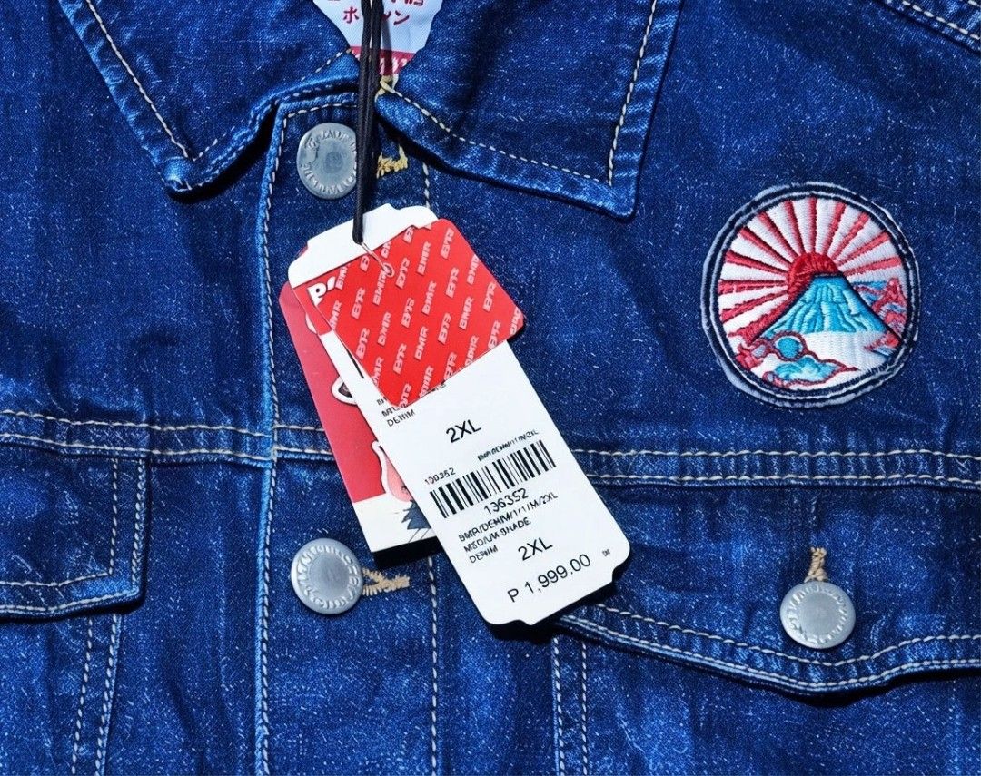 Bobson x Tom and Jerry Denim Jacket Size 2XL (Category: Coats, Jackets and Outerwear) located in Manila. Submitted by navias (Listing ID 1466638783, Image 2). Description: - Brand: Bobson - Condition: Brand new with original price tag attached, never worn - Size: 2XL - Color: Medium blue - Design: Tom and Jerry graphic print on the back, embroidery patches on the front chest and pockets - Closure: Button-up with metallic buttons.