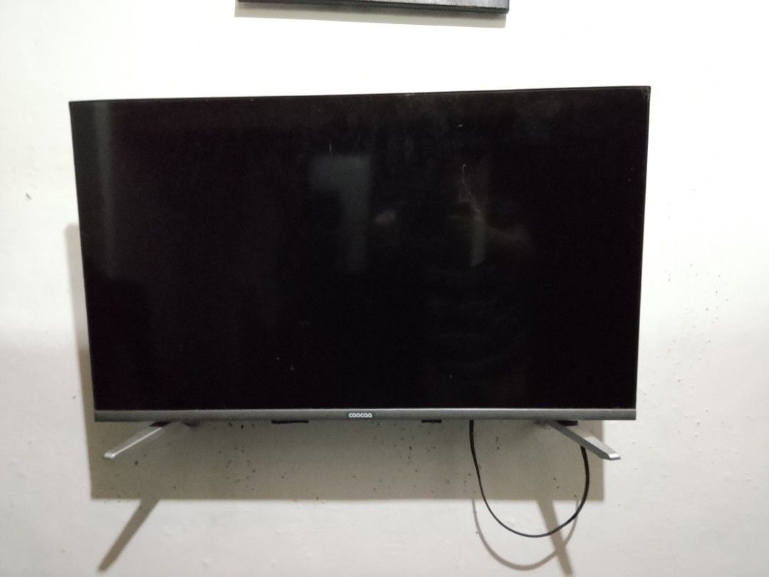 Broken Coocaa television screen (Category: TV) located in Manila. Submitted by roxxdeloss46067 (Listing ID 1466587992, Image 2). Description: - Brand: Coocaa TV - Condition: Screen cracked top right, heavy display distortion - Best for: Spare parts or repair project - Inclusions: Attached stand legs and connected power cable - Delivery: Pick up preferred due to fragile screen state.