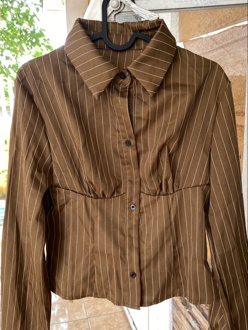 Brown Pinstripe Button-Up Long Sleeve Blouse (Category: Longsleeves) located in Cavite. Submitted by helloize (Listing ID 1466601376, Image 1). Description: Personal favorite 🤎 Smooth texture ng fabric Di gaanong gusutin Lp is 300 Fits XS-S.
