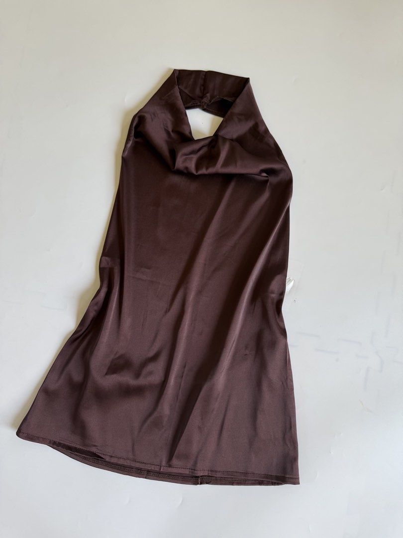 Brown Satin Halter Top Cowl Neck Open Back (Category: Sleeveless) located in Tarlac. Submitted by kr_closet (Listing ID 1466705309, Image 2). Description: - Color: Dark brown - Material: Smooth, shiny satin with a great drape - Design: Halter top with cowl neckline and open back - Style: Sleeveless with a clean bottom hem - Versatility: Perfect for going out, easily pairs with high-waisted jeans or skirts.
