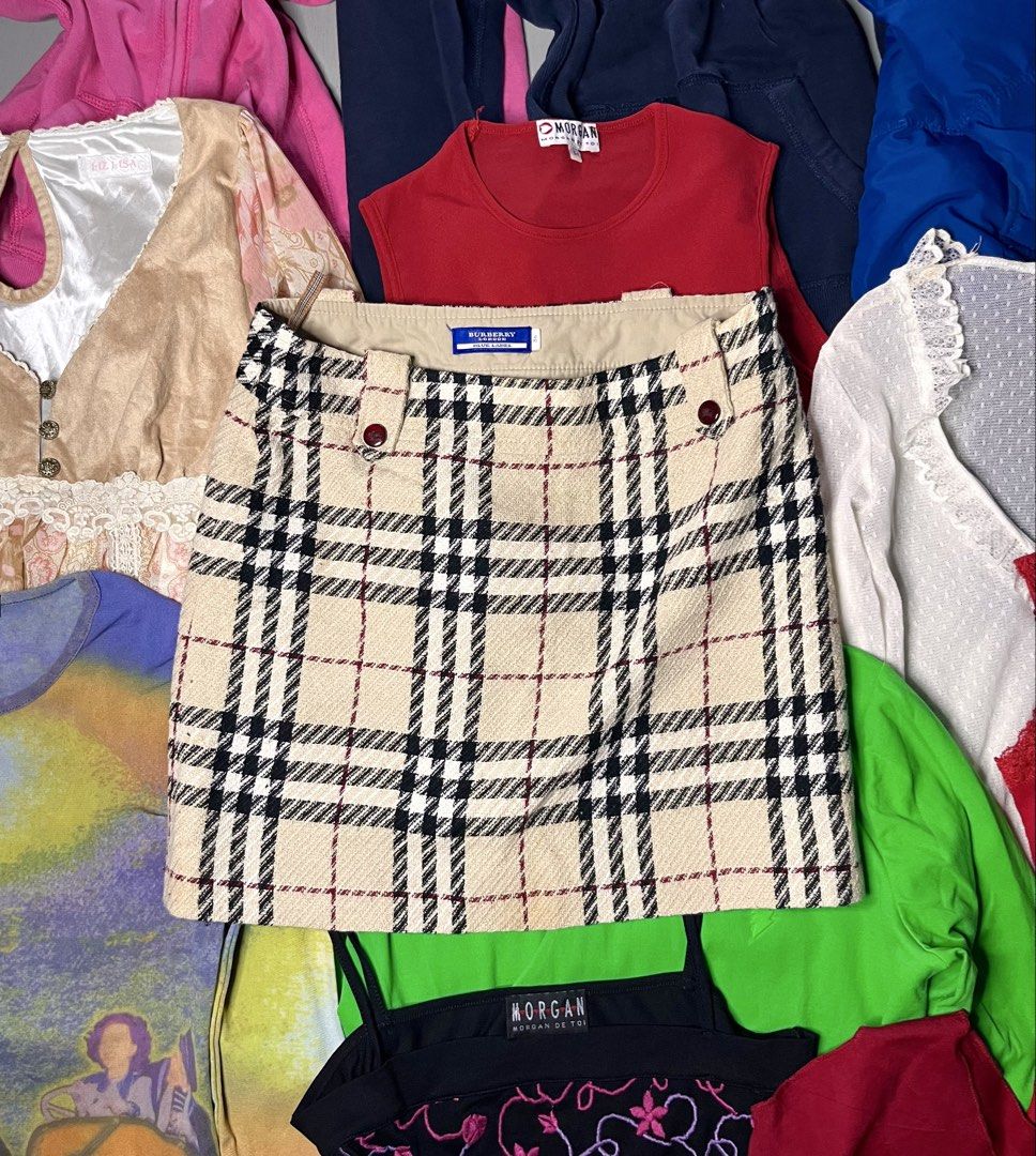 Burberry Blue Label Plaid Mini Skirt (Category: Skirts) located in Catbalogan. Submitted by yellfindss (Listing ID 1466755516, Image 1). Description: Burberry Blue Label mini skirt in classic beige check pattern. Black and red lines throughout. Structured wool-blend fabric with smooth lining inside. Side zipper closure. Branded red buttons on the waist tabs. Interior features signature Nova check hanging loops. Size 36 tag on the inner label. Y2K