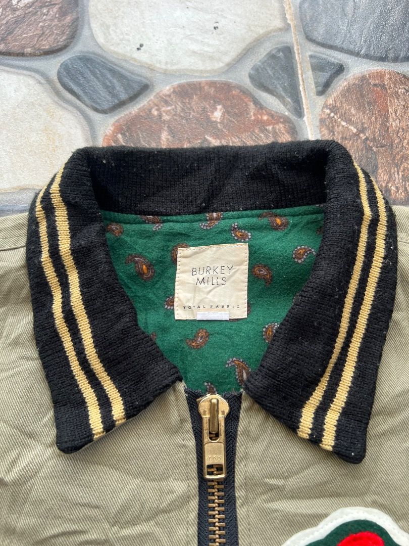 Burkey Mills Green Bomber Jacket with Patch Vintage (Category: Coats, Jackets and Outerwear) located in Caloocan City. Submitted by sillapwet0606 (Listing ID 1466567293, Image 2). Description: - Brand/Style: Burkey Mills olive green corduroy bomber jacket - Details: Bold red chest patch, YKK brass zipper, and green paisley-print lining - Ribbing: Black and gold striped collar, cuffs, and hem - Condition: Noticeable staining and discoloration near