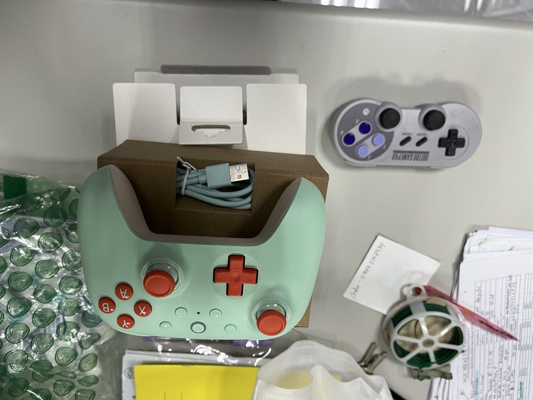 Buy 1 take 1 8BitDo Pro 2 Bluetooth Gamepad Mint Green (Category: Controllers) located in Manila. Submitted by ncmbrbgddf58183 (Listing ID 1466615889, Image 1). Description: - Authentic 8BitDo wireless Bluetooth gamepad in mint green - Eye-catching orange d-pad and action buttons - Includes matching light blue USB charging cable and original box packaging - Bonus: Extra grey SNFC-style controller included in the bundle - Compatible with multiple 