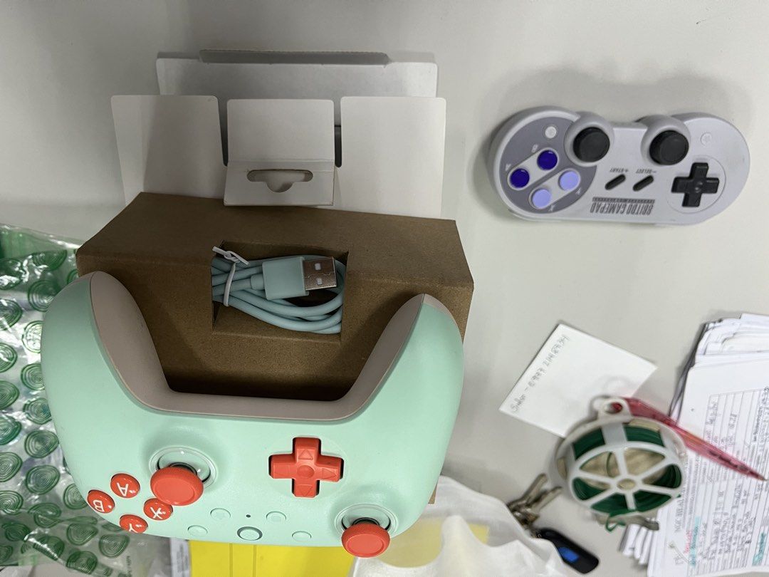 Buy 1 take 1 8BitDo Pro 2 Bluetooth Gamepad Mint Green (Category: Controllers) located in Manila. Submitted by ncmbrbgddf58183 (Listing ID 1466615889, Image 2). Description: - Authentic 8BitDo wireless Bluetooth gamepad in mint green - Eye-catching orange d-pad and action buttons - Includes matching light blue USB charging cable and original box packaging - Bonus: Extra grey SNFC-style controller included in the bundle - Compatible with multiple 