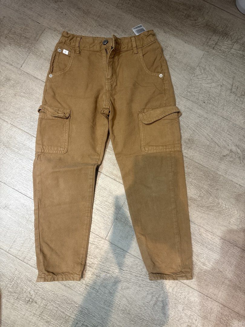 Calvin Klein Jeans Brown Cargo Pants Size 6 (Category: Babies & Kids Fashion) located in Quezon City. Submitted by zencat.693786 (Listing ID 1466591182, Image 1). Description: - Brand: Calvin Klein Jeans - Size: 6 (tag inside waistband) - Color: Versatile brown - Style: Classic cargo pockets with snap buttons - Comfort: Elastic waistband design at the back for easy movement - Material: Durable fabric, perfect for everyday kids' wear - Condition: 