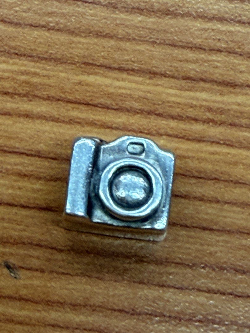 Camera charm silver bead bracelet accessory (Category: Charms) located in Quezon City. Submitted by ellamenopi (Listing ID 1466659671, Image 1). Description: - Silver camera charm designed for bracelets, chains, or cords - Detailed lens and flash engravings on the front - Cute screen graphic detail on the back - Small hole through the middle for easy sliding - Minor signs of wear on the metal finish - Great gift idea for photography lovers.